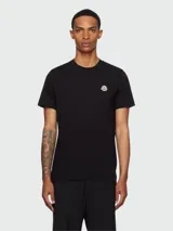 Remera de manga corta en color negro, confeccionada en algodón, con cuello redondo y el logo de la marca aplicado en el pecho.