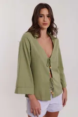 Camisa verde oliva de lino con cuello camisero, mangas 3/4 acampanadas y cierre frontal con lazos y cuentas de madera.