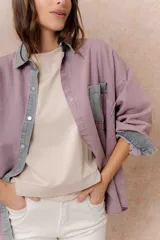 Camisa de denim color verde menta con calce relajado, cuello clásico, cierre frontal con broches metálicos, mangas largas y bolsillo aplicado en el pecho, con detalles en tono gris azulado a contraste en cuello, cartera, bolsillo y puños.