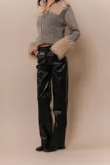 Pantalón recto de cuerina texturizada tipo charol color negro, con cuatro bolsillos y mini cinturón a tono.