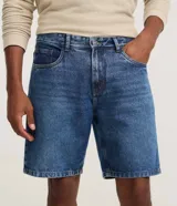 Bermuda de jeans de corte recto y tiro medio, con cierre de botón y cremallera, bolsillos laterales y traseros, y trabillas para cinturón.