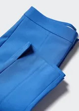 Pantalón skinny crop de tiro alto, con diseño entallado y cierre oculto de botón, gancho y cremallera. Presenta bolsillos de ribete en la parte posterior y un pequeño tajo en el ruedo.