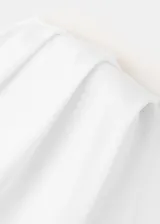 Camiseta blanca de diseño asimétrico con detalles fruncidos y manga corta.