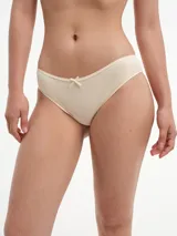 Bombacha tipo bikini de algodón, color beige, con detalle de puntilla en los bordes y pequeño lazo decorativo en el centro de la cintura.