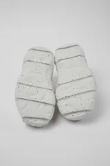 Championes negros con cordones gruesos en blanco y negro, suela gruesa con textura y puntera reforzada.