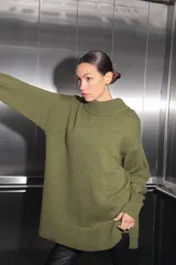 Sweater verde oliva de tejido de punto con cuello polo, mangas largas y corte oversize. Presenta un parche con monograma en la espalda.