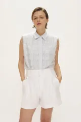 Short de tiro alto color blanco con bolsillos frontales y cierre con broches sastreros.