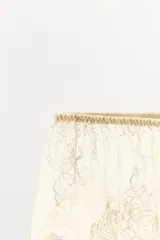 Shorts semitransparentes de encaje suave con tiro medio, cintura elástica y bordados florales a tono.