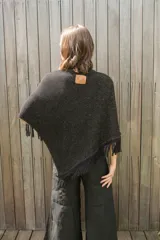 Poncho tejido en hilo de algodón, color rojo, con diseño de cuello redondo y terminaciones con flecos en el ruedo.