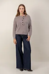 Sweater de punto con textura suave, color gris topo, de manga larga y cuello redondo con abertura frontal y cierre de botones oscuros.