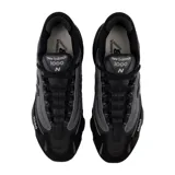 Championes urbanos New Balance modelo 1000, color negro con detalles en gris oscuro. Presentan un diseño técnico con capas superpuestas de malla y material sintético, logo N en el lateral y numeración 1000 bordada en la puntera. Cuentan con una suela robusta y amortiguada.