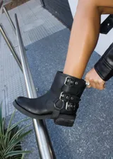 Botas cortas negras de cuero vacuno, con hebillas plateadas, cierre lateral y estribo desmontable.