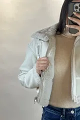 Campera tipo gamulán de cuero sintético negro, con interior y detalles de cuello y puños en corderito blanco. Presenta cierre frontal, cierres en los puños y correas ajustables en la cintura.