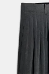 Pantalón de tiro medio con pinzas frontales, confeccionado en tejido con viscosa. Presenta cintura con trabillas, bolsillos laterales y cierre frontal con cremallera, botón y ganchos metálicos.