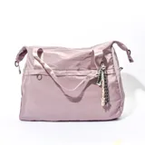 Bolso tipo tote de tela color lila con doble asa de mano y correa larga regulable.