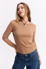 Remera de manga larga con cuello redondo y ajuste al cuerpo, confeccionada en tejido de algodón con textura acanalada.