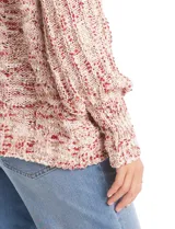 Buzo tejido en punto aran con cuello volcado y mangas largas con puño. Presenta un diseño jaspeado en tonos rosados y beige.