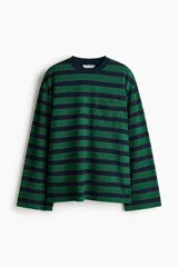 Remera de punto a rayas horizontales en color verde y azul marino, con cuello redondo, mangas largas de hombros caídos y un bolsillo de parche en el pecho.