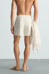 Bañador de hombre color azul marino, confeccionado en tejido técnico, con cintura elástica ajustable mediante cordón. Presenta bolsillos laterales y un bolsillo trasero de plastrón. Incluye forro interior.