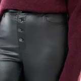 Pantalón de cuero sintético negro de corte recto, con cierre frontal de botones a la vista y tiro alto.