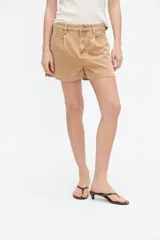 Short de jean tiro alto en color marrón claro, con pinzas delanteras y calce relajado.