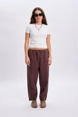 Pantalón casual marrón de corte holgado y relajado, con cintura elástica y cordón ajustable.