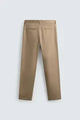 Pantalón chino de corte regular fit, confeccionado en tejido de algodón con elasticidad. Presenta bolsillos frontales, bolsillos traseros de vivo y cierre frontal con cremallera y botón.