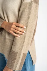 Sweater de punto con diseño de bloques de color en tonos beige y marrón, de corte oversize, cuello redondo y mangas largas con puños acanalados.