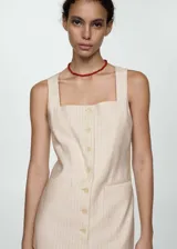 Vestido corto de diseño recto y fluido, con estampado de rayas verticales. Presenta escote cuadrado, tirantes anchos, cierre frontal con botones y dos bolsillos de ribete delanteros.