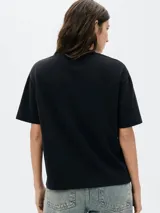 Camiseta de manga corta color blanco hueso, con cuello redondo y bolsillo de parche en el pecho.