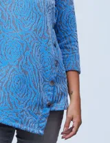 Buzo azul de tejido soft labrado marca Ruby Rd, con cuello volcado, delantera superpuesta, aplique de botones y terminación de ruedo asimétrico.