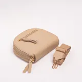 Bandolera semicircular de cuero sintético color beige, con doble compartimento con cierre, bolsillos frontales con cierre y tiradores decorativos. Incluye correa ajustable y desmontable.