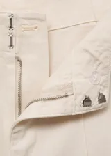 Pantalón de tiro alto estilo wide leg, color blanco, con trabillas para cinturón, bolsillos laterales y cierre oculto con botón, gancho y cremallera. Confeccionado en tejido de algodón.