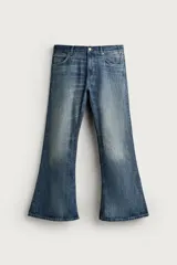 Jeans flare fit de tiro medio, confeccionados en denim de algodón color azul con efecto deslavado. Diseño ajustado en la parte superior y abierto en campana desde la rodilla, con cinco bolsillos y cierre frontal con cremallera y botón.