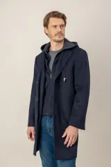 Chaquetón de lana color azul marino, con diseño de doble capa que incluye una capucha integrada y cierre frontal. Presenta solapas clásicas y corte recto.