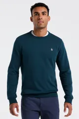 Buzo de cuello redondo en color azul petróleo, confeccionado en tejido de punto fino. Presenta puños y ruedo acanalados, con el logo de la marca bordado en el pecho.