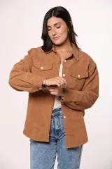 Camisa de pana fina color beige, con cuello clásico, cierre frontal de botones y dos bolsillos con solapa en el pecho.