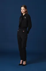 Chaleco negro de corte corto y estructurado, con cierre frontal y diseño minimalista.