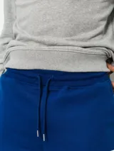 Pantalón de jogging azul con cordón ajustable en la cintura y gran estampado vertical de la marca en la pierna izquierda.
