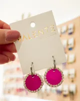 Aros colgantes con aro de acero plateado y dije circular fucsia con borde de strass.