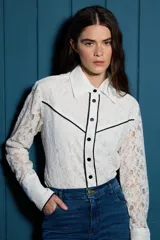 Camisa de encaje de algodón color blanco, con diseño de estilo western, cuello clásico, cierre frontal de botones y detalles de ribetes en contraste color negro.