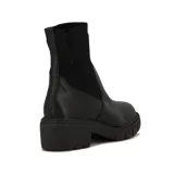 Bota Beira Rio de caña media, color negro, con cuerpo de cuero sintético y caña de tejido elástico acanalado. Cuenta con taco bloque de 4 cm y suela track dentada.