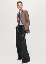 Pantalon de tiro medio efecto piel con diseño wide leg, bolsillos laterales, pinzas delanteras y cierre frontal de botón, gancho y cremallera ocultos.