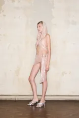 Top estilo bralette con lentejuelas plateadas que se ata en el cuello y la espalda con tirantes de satén. Cuenta con un forro de malla en tono nude.