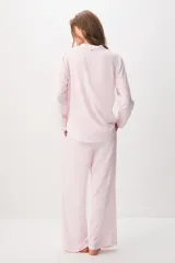 Pijama rosado de 100% viscosa con diseño a rayas sutiles, compuesto por una camisa de manga larga con cuello solapa y botones delanteros, y un pantalón largo de corte holgado con cintura elástica y cordón ajustable. Presenta un pequeño detalle bordado de corazón rojo en el pecho de la camisa.