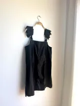 Vestido corto negro de cuero vacuno con breteles finos regulables y corte evasé.