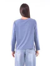 Remera de manga larga color azul, con cuello redondo y un estampado central de flores en tonos pastel sobre un recuadro gris claro.