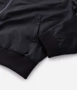 Campera bomber negra para hombre, confeccionada en poliéster con cierre frontal de cremallera, cuello, puños y dobladillo elásticos acanalados, y bolsillos laterales.