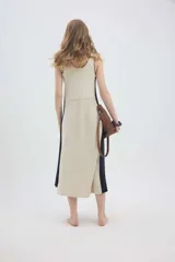 Vestido midi de punto sin mangas, con escote redondo, diseño bicolor en tonos marrón y amarillo, y corte holgado.