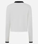 Cardigan de punto color blanco con detalles en negro en cuello, puños y tapeta frontal. Presenta cierre frontal con botones perlados y dos bolsillos delanteros falsos con solapa bicolor.